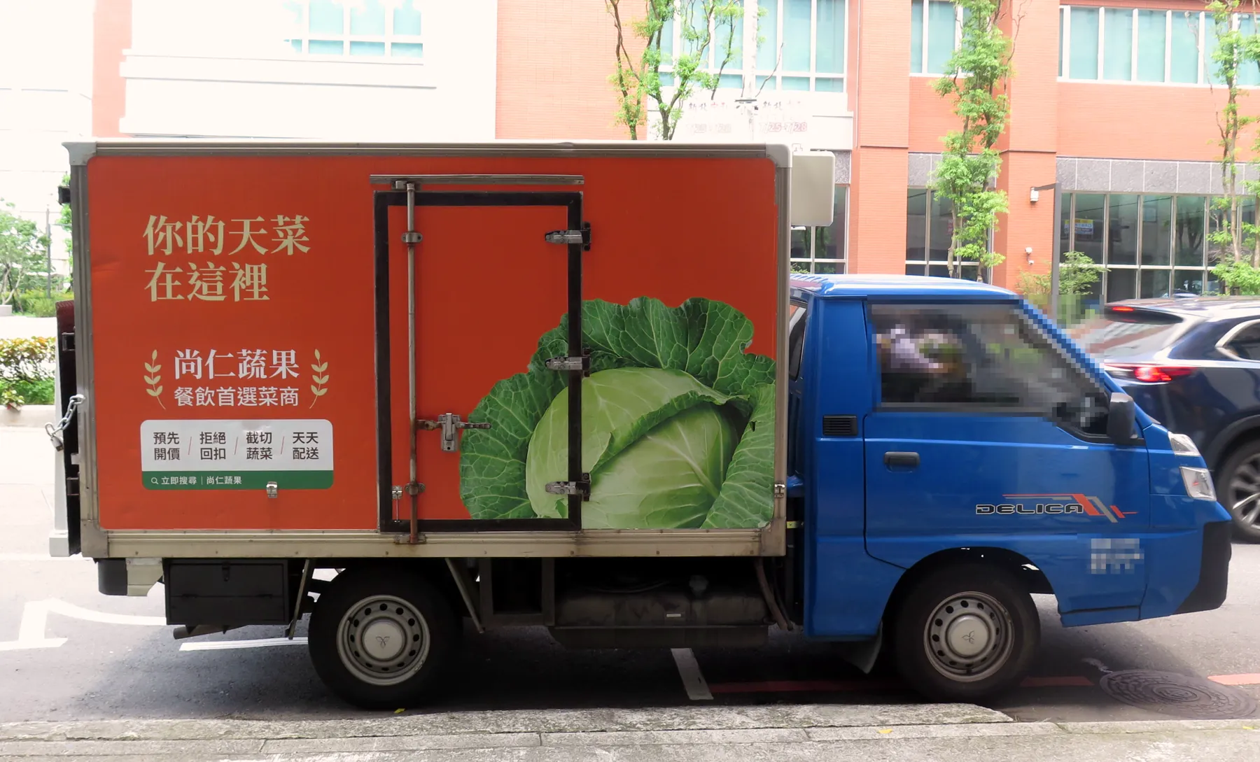 尚仁蔬果低溫配送車側面,車身寫著預先開價、拒絕回扣、截切蔬菜、天天配送